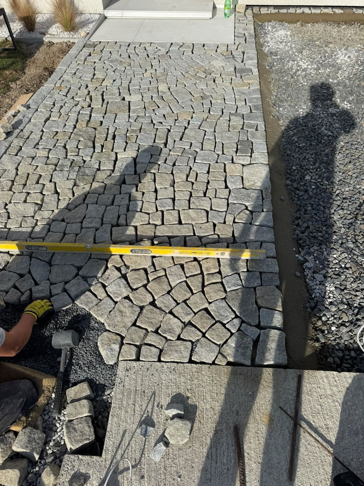 Pokládka žulové kostky do štěrkového lože s kontrolou roviny vodováhou