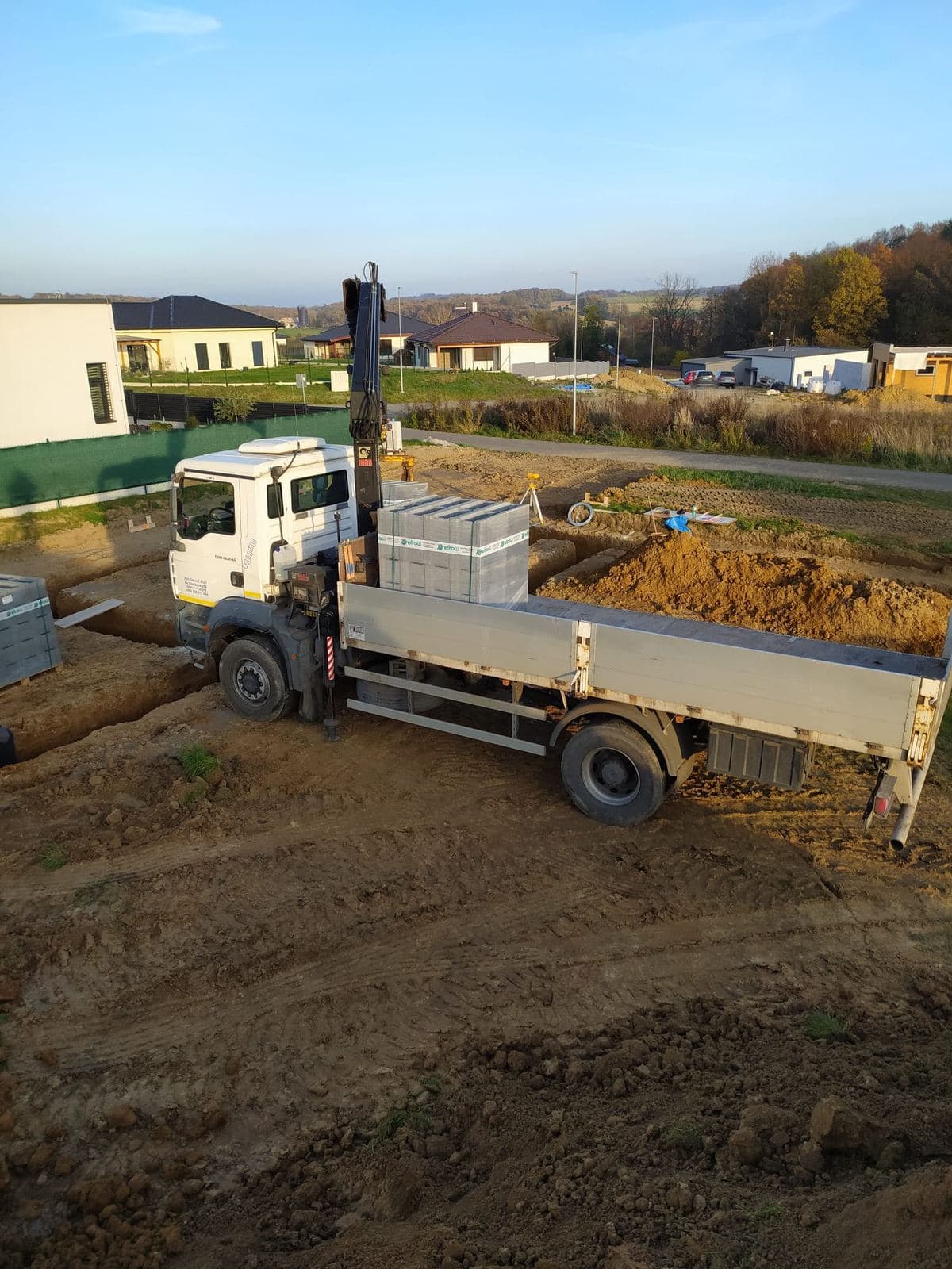 Dovoz pórobetonových tvárnic nákladním autem s hydraulickou rukou na stavbu