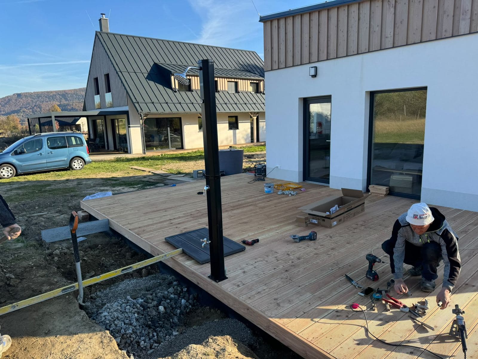 Montáž dřevěné terasy z modřínových prken u novostavby s dřevěným obkladem